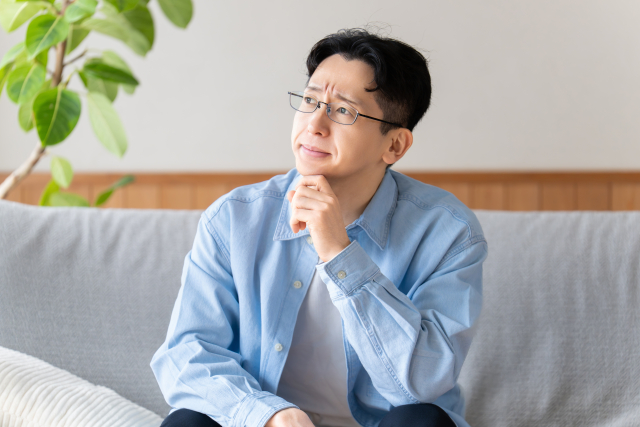 動かないオメガを修理してから売るべきか現状のまま売るべきか悩む男性