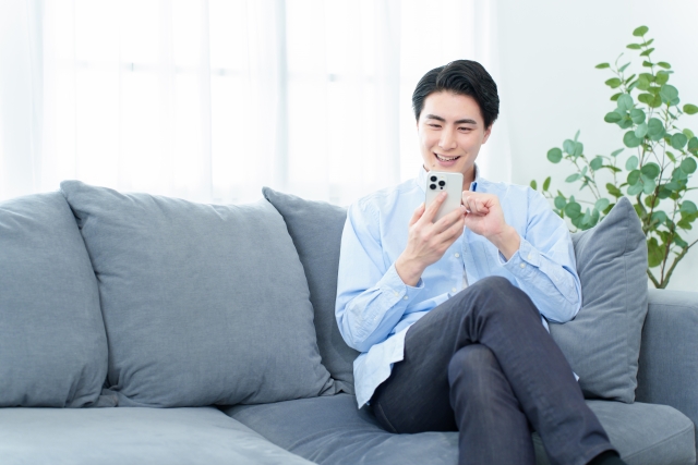自宅でLINE査定をする男性